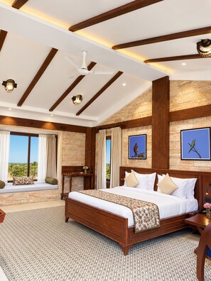 A spacious bedroom with a large bed, wooden beams, stone walls, and a view of the outdoors. - The Blackbuck Trails Velavadar (Bhavnagar)