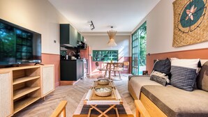 A modern living room with a sofa, TV, and dining area. - Casa Oliva (Mexico City)