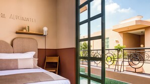 A bedroom with a large window, a bed, a nightstand, and a wall-mounted shelf. - Casa Oliva (Mexico City)