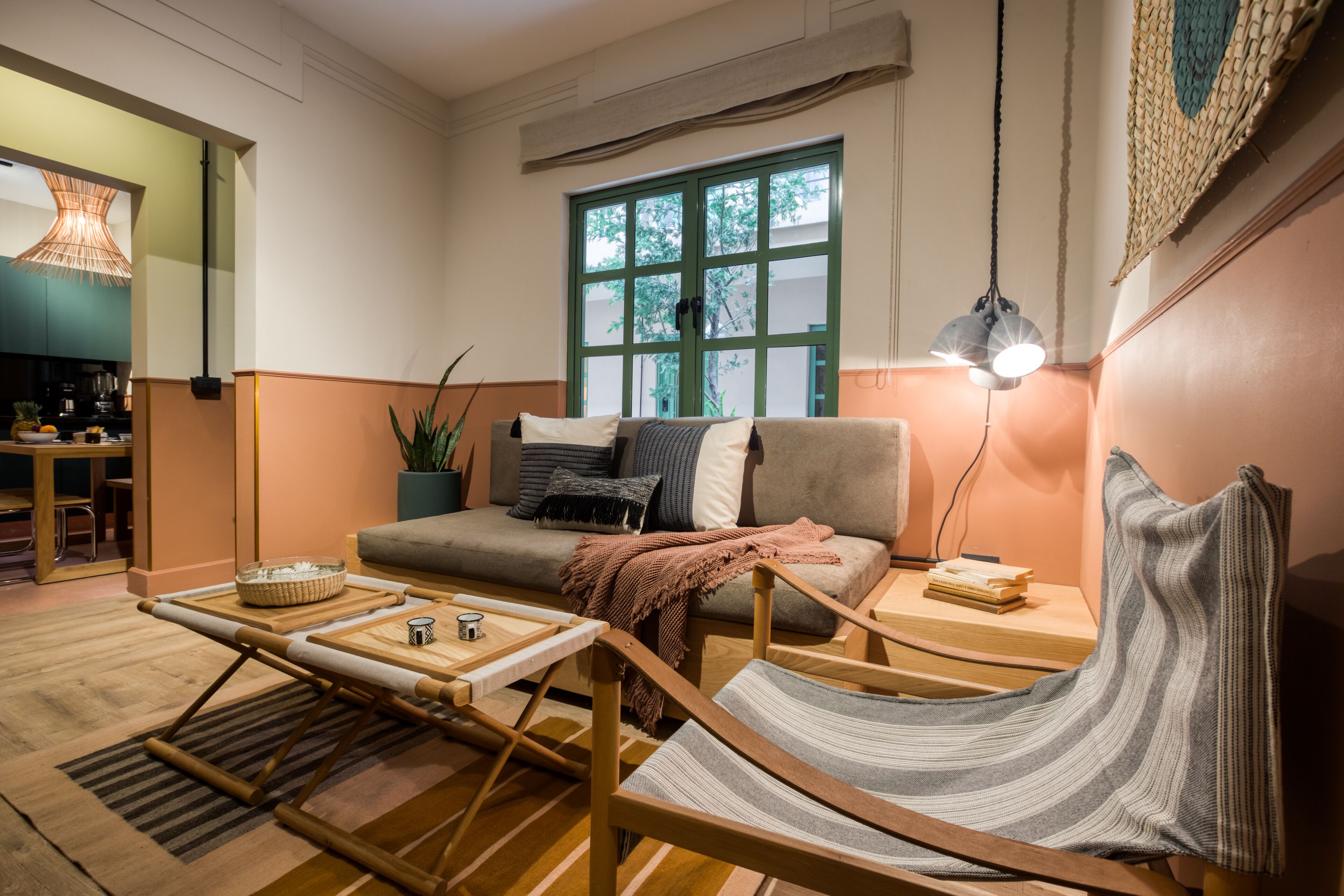 A cozy living room with a sofa, a hammock, a coffee table, and a dining area with a table and chairs.
