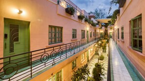 A multi-level hotel corridor with balconies, checkered flooring, and green doors. - Casa Oliva (Mexico City)