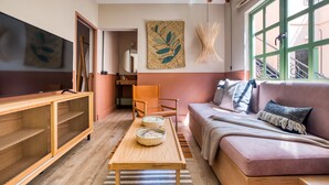 A cozy living room with a sofa, a coffee table, and a TV. - Casa Oliva (Mexico City)