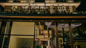 Un edificio de varios pisos con balcones, ventanas amplias y un diseño arquitectónico moderno.