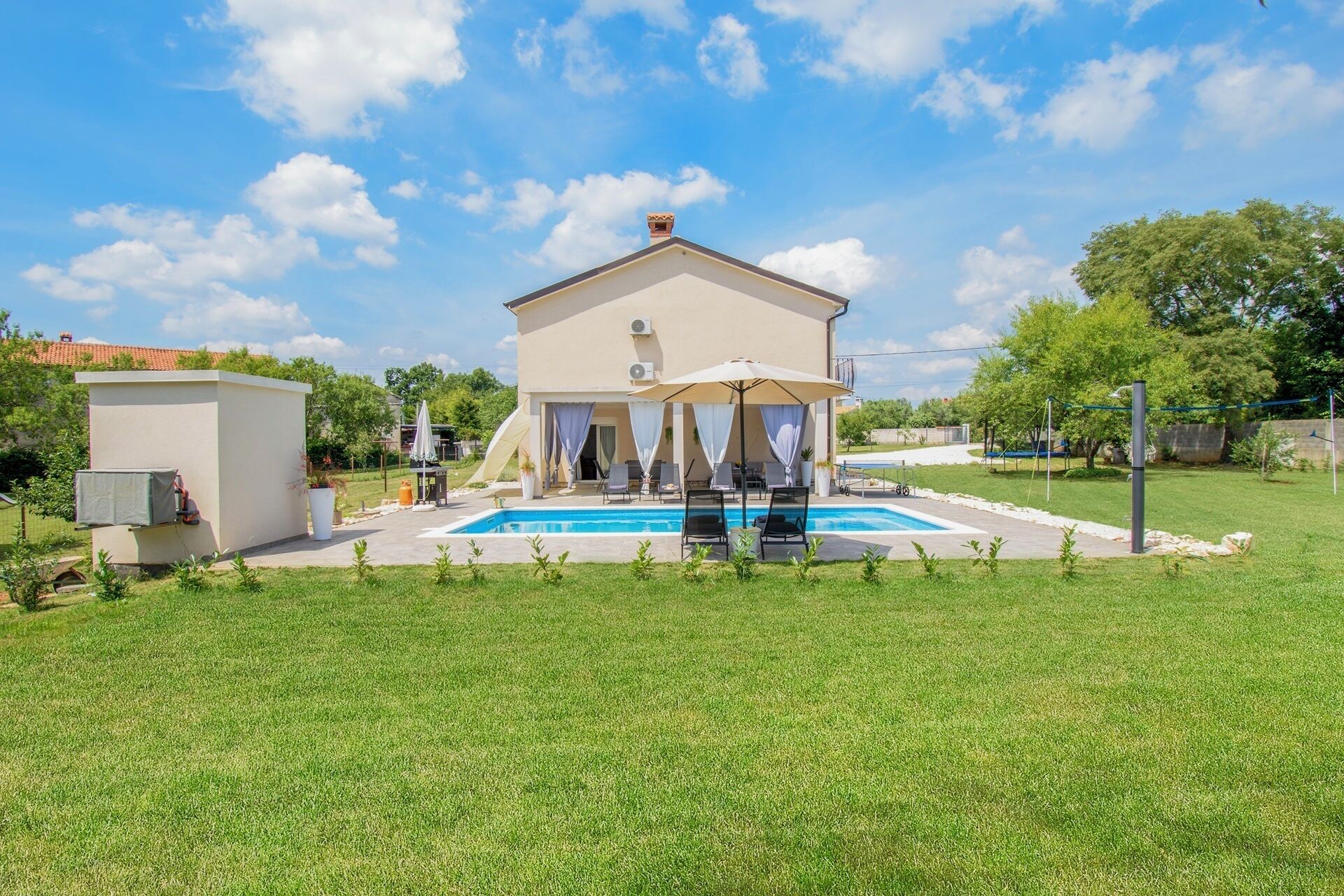 Uma casa de dois andares com piscina, área de estar externa e varanda coberta.