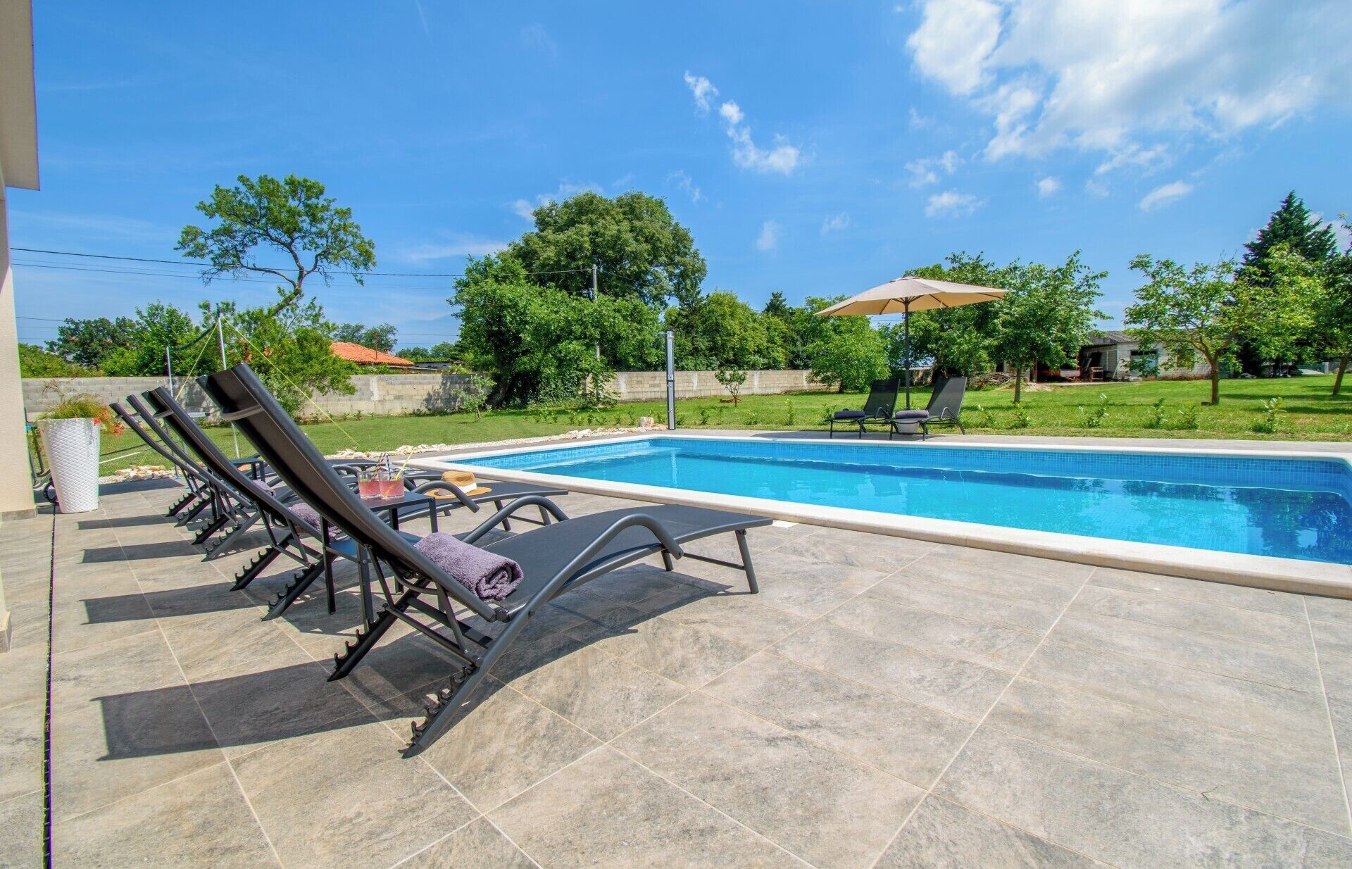 A swimming pool with lounge chairs and a patio area.