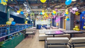 A cozy indoor space with seating areas, a bar, and a neon sign. - Treebo Shankuntalam, Near Lucknow Airport  (Lucknow)