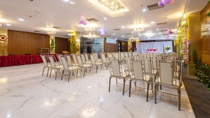 A banquet hall with rows of chairs, a stage with draped curtains, and chandeliers. - Treebo Shankuntalam, Near Lucknow Airport  (Lucknow)