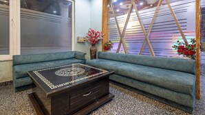 A modern room with a sofa, a coffee table, and a decorative vase with flowers. - Treebo Shankuntalam, Near Lucknow Airport  (Lucknow)