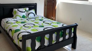 Une chambre à coucher avec un lit, une porte et une fenêtre équipée de stores.