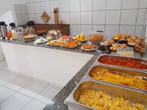 A buffet setup with various food items and condiments. - Pousada Pimenta Nativa (Porto Seguro)