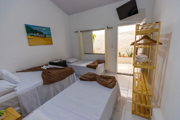 A room with three beds, a TV, a painting, and a wooden shelf. - Pousada Pimenta Nativa (Porto Seguro)
