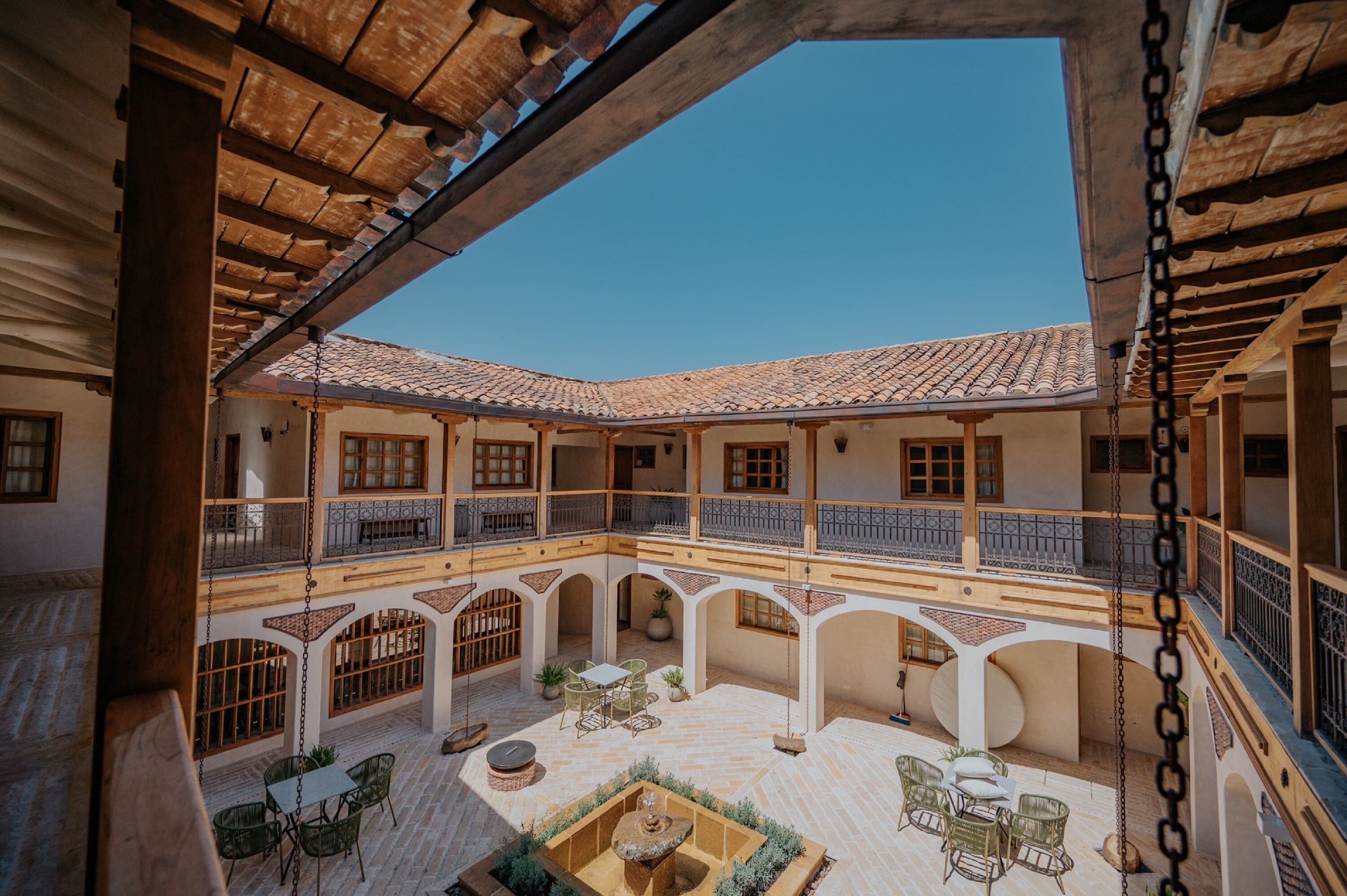 A courtyard with multiple levels, wooden beams, and tiled roofs.
