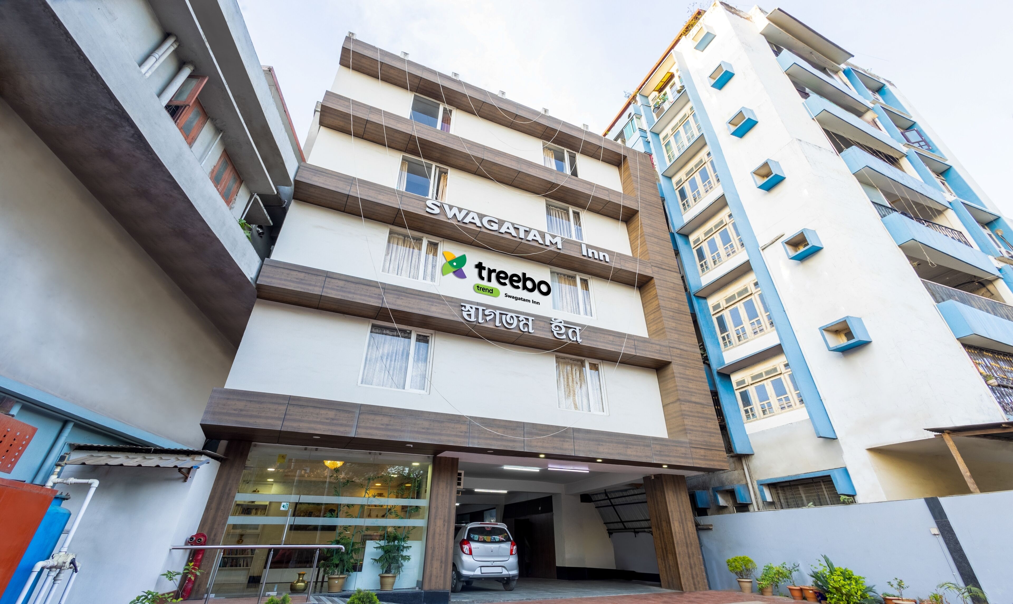 A multi-story building with a sign for Swagatham Inn and Treebo Trend.