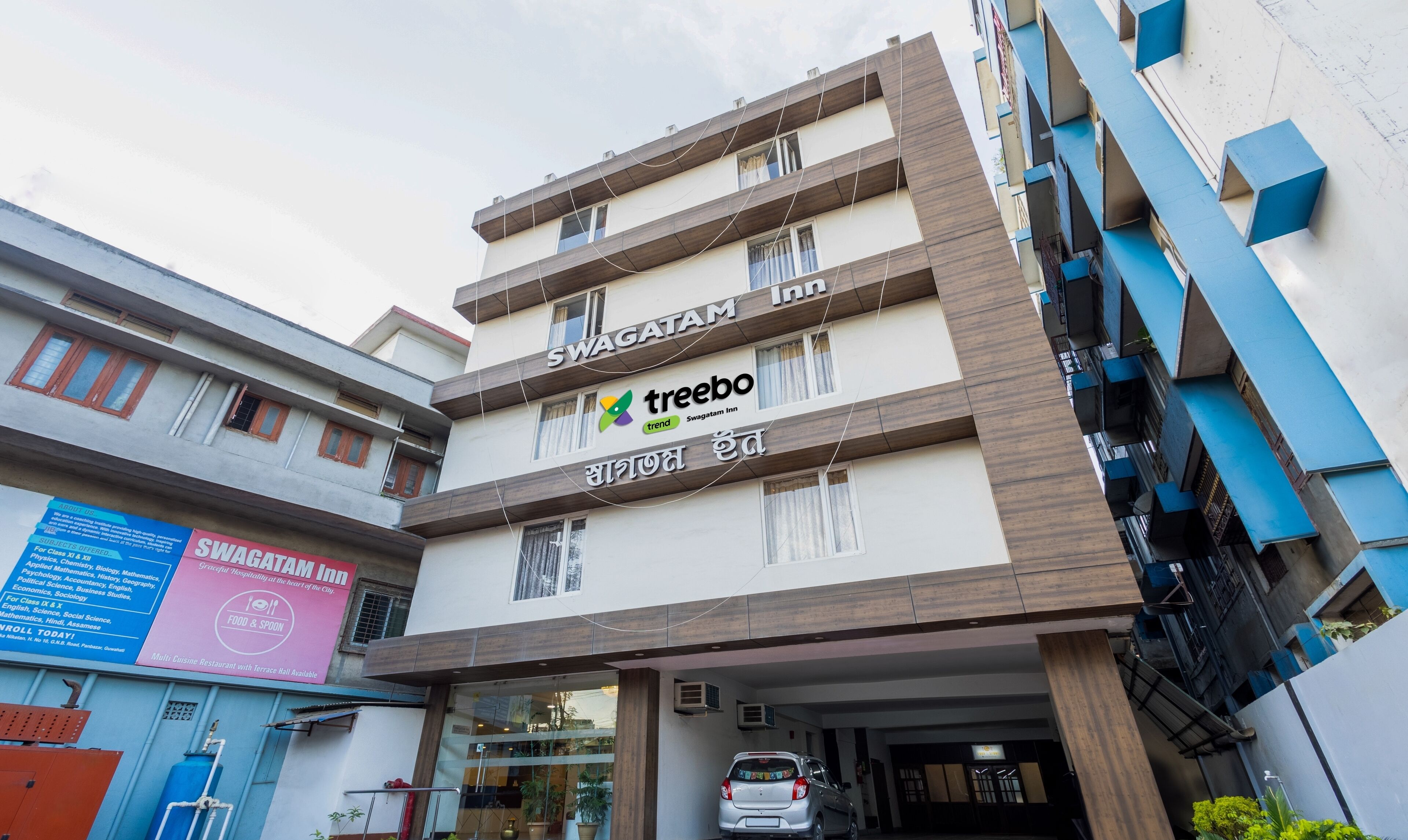 A multi-story building with a Swagatam Inn sign, indicating it is a hotel.