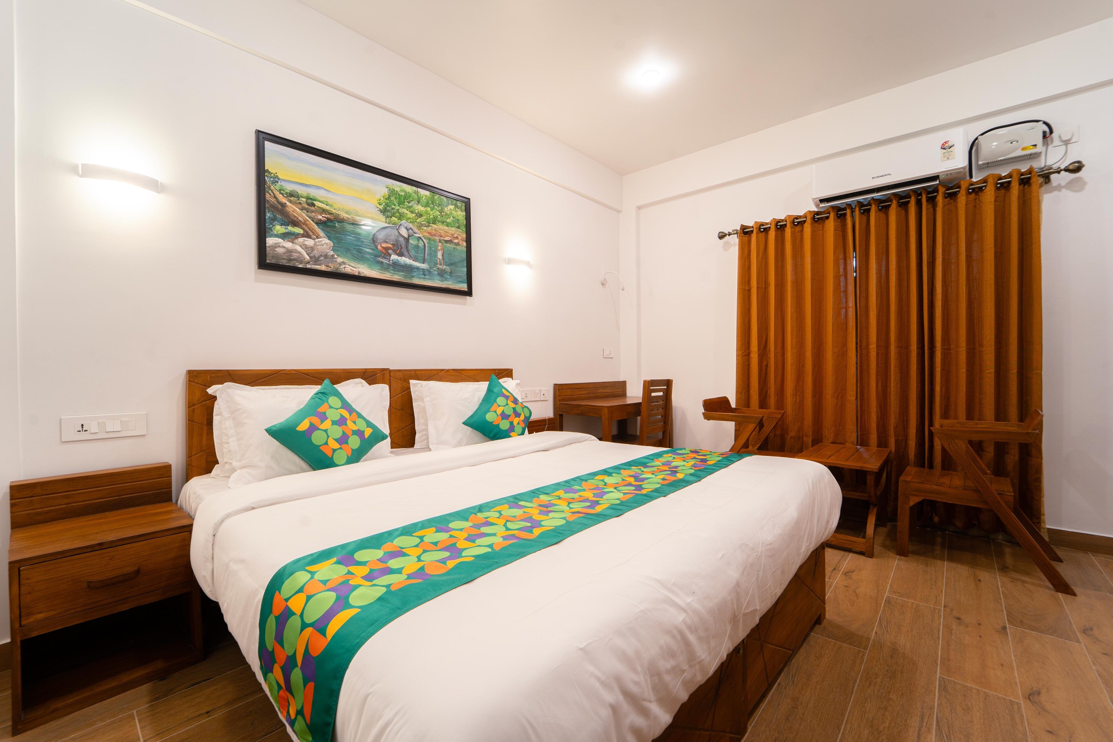 Una camera d'albergo ordinata con un letto grande, una testiera in legno e un quadro appeso al muro.