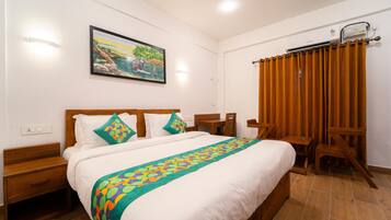 Una camera d'albergo ordinata con un letto grande, una testiera in legno e un quadro appeso al muro.