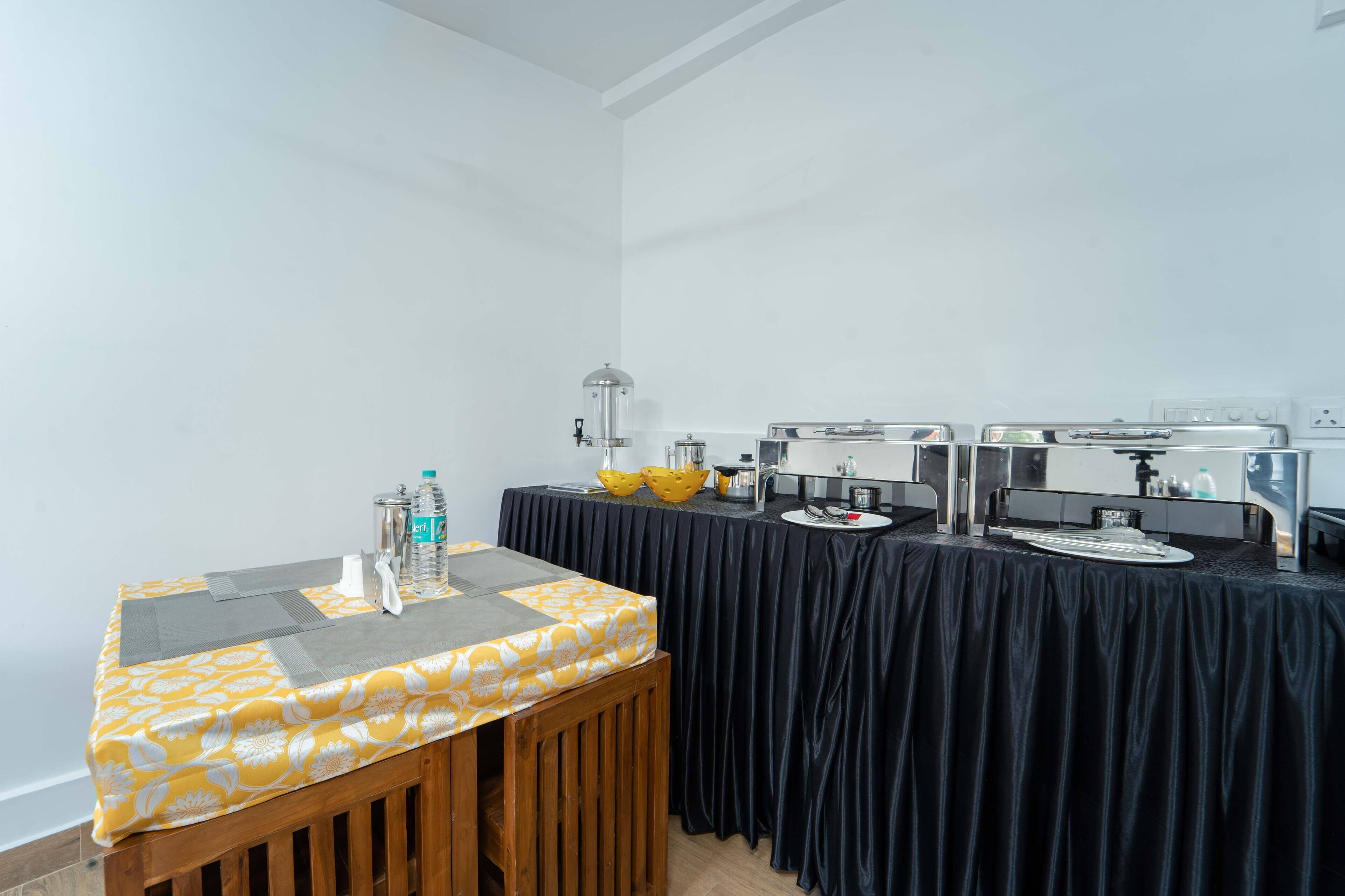 A conference room with a black tablecloth, a wooden bench, and a yellow patterned tablecloth.