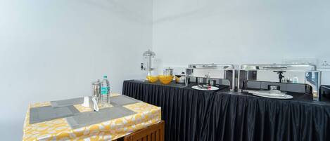 A conference room with a black tablecloth, a wooden bench, and a yellow patterned tablecloth.