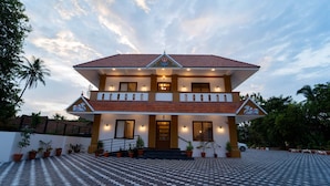 A two-story house with a tiled roof, a balcony, and a paved entrance area. - Treebo West Fort Divine – Near Padmanabhaswamy Temple (Thiruvananthapuram)
