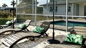 Un espace aménagé au bord de la piscine, avec des chaises longues et des parasols jaunes.