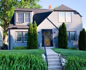 Stunning two-story house with a central entrance and beautifully manicured lawn.