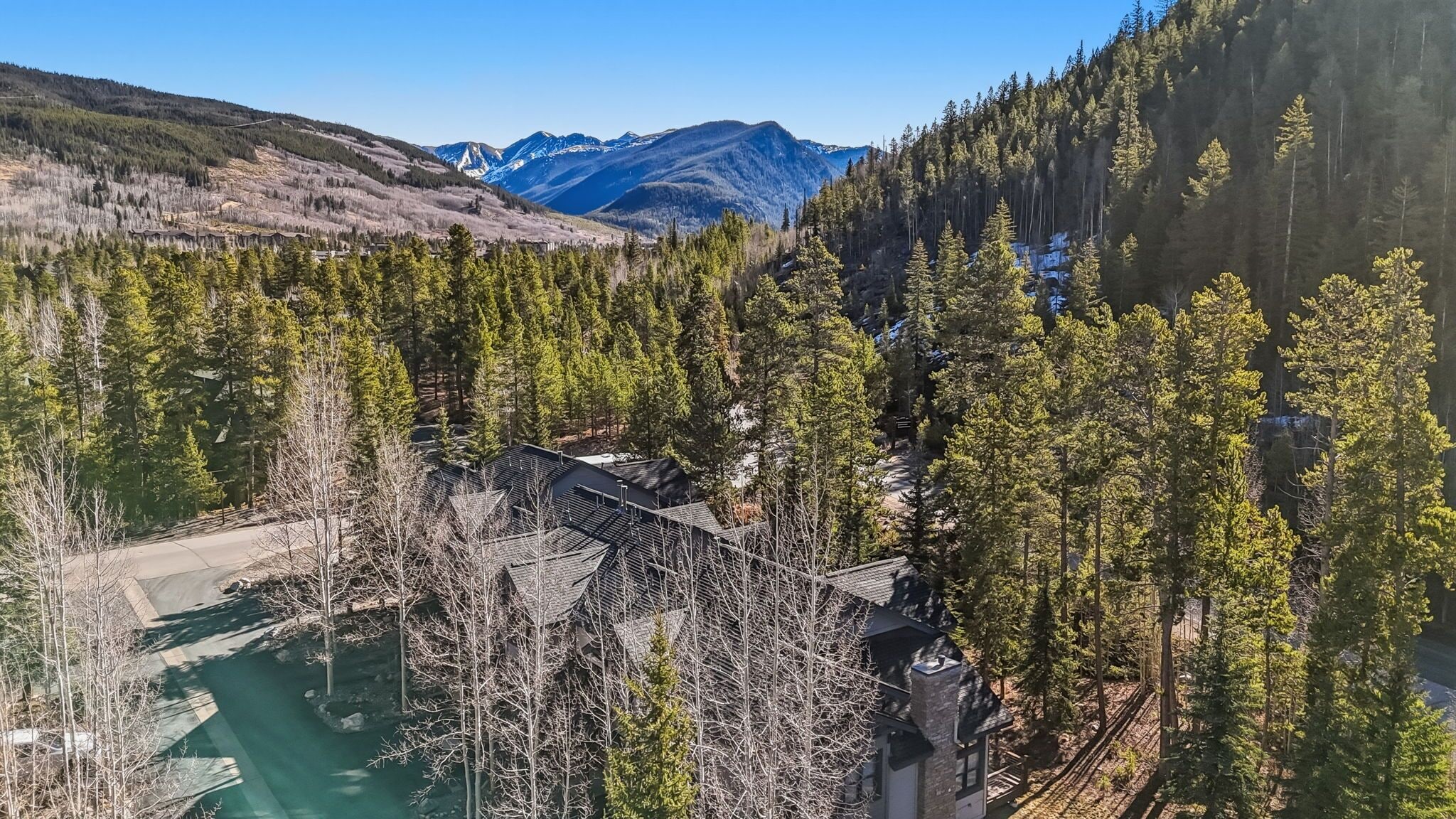 Una cabaña en la montaña con vistas a un bosque y montañas.