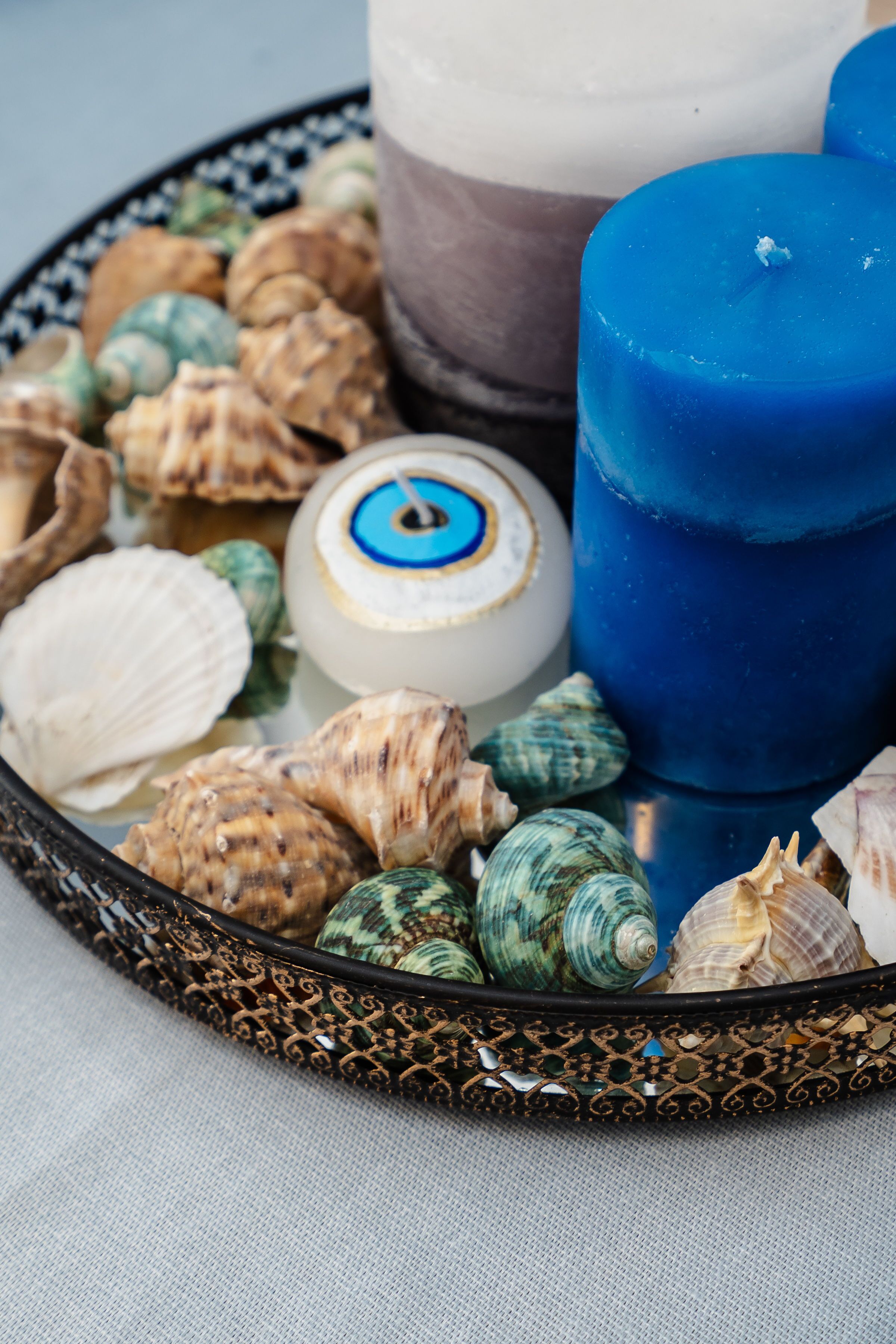 A tray with seashells and candles.
