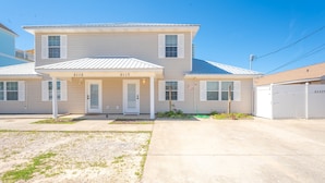 A two-story residential building with a front porch, numbered 5115 and 5117.