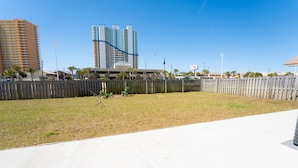 A fenced yard with a grassy area and a concrete path.