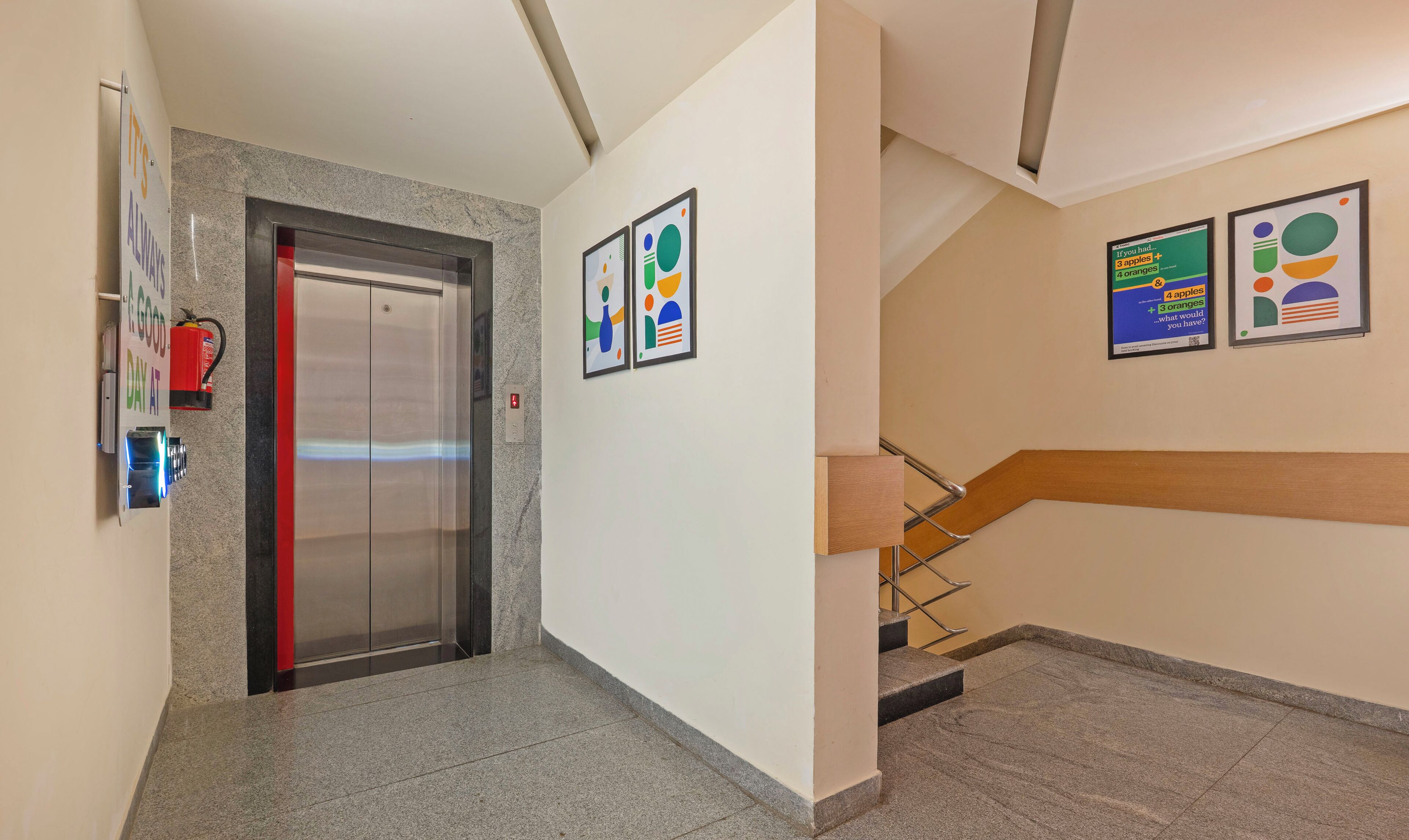 A hallway with a fire extinguisher, an elevator, and a staircase.