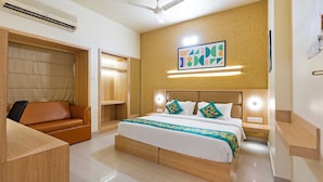 Ein Hotelzimmer mit Bett, Sofa, Kleiderschrank und Deckenventilator.