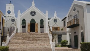 Església amb entrada central, una torre campanar i una escala que mena a l'entrada.