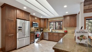 Una cocina moderna con armarios de madera, electrodomésticos de acero inoxidable y encimera de granito.