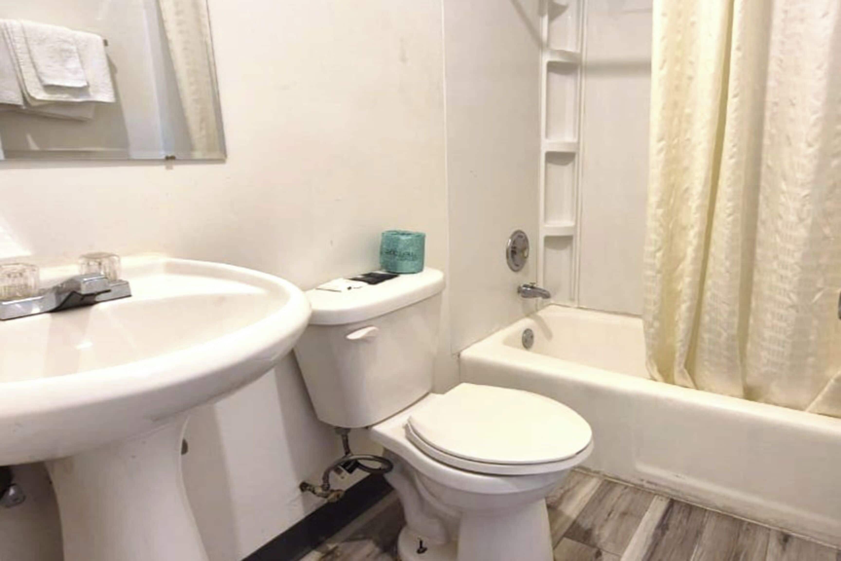 A bathroom with a sink, toilet, and bathtub.