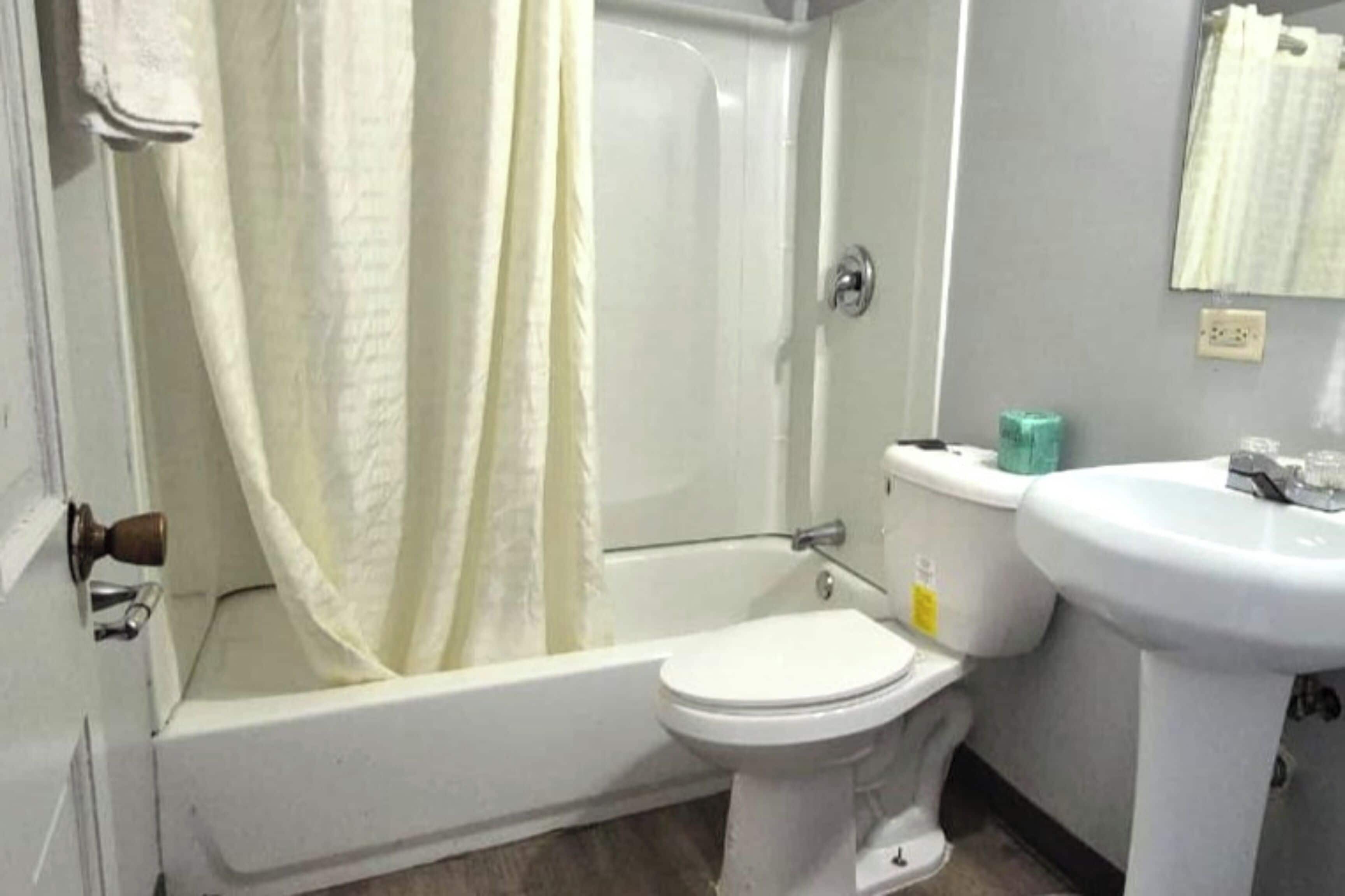 Un baño con bañera, inodoro y lavamanos.