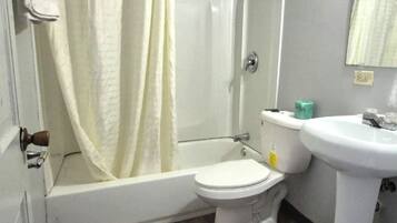 Un baño con bañera, inodoro y lavamanos.
