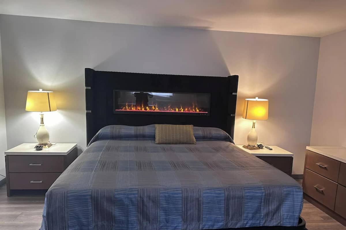 Suite, 1 très grand lit (Jacuzzi & Electric Fire Bed) | Coffres-forts dans les chambres, bureau, fer et planche à repasser