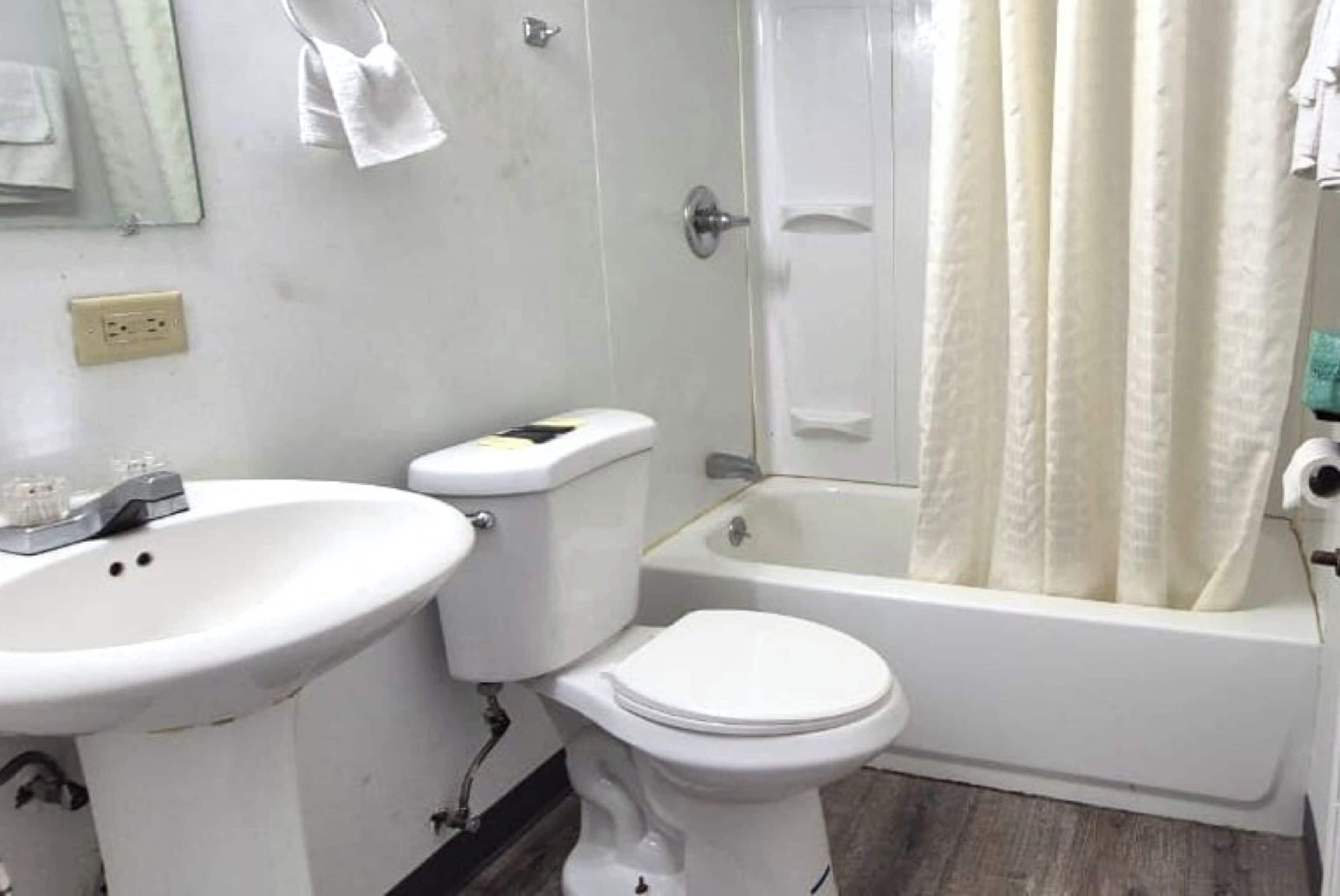 A bathroom with a sink, toilet, and bathtub.