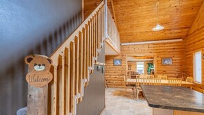 Un intérieur en bois comprenant un escalier, un coin repas et une cuisine.