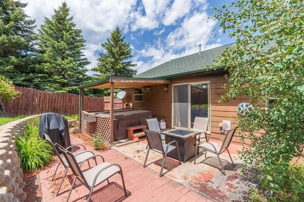 A patio with outdoor furniture, a barbecue grill, and a covered seating area.