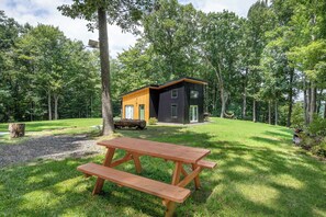 A cabin with a picnic table in a forested area.