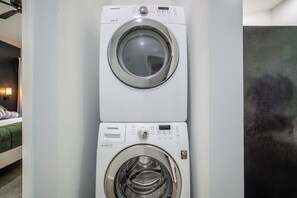 A wall-mounted washer and dryer unit with a control panel and a digital display.