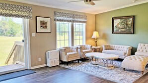Un salon avec un ensemble de canapés de couleur beige, une table basse ronde et un tapis à motifs.