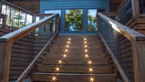 A wooden staircase with metal railings leading to a building entrance.