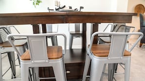 Ein Essbereich mit einem dunklen Holztisch und vier Metallstühlen mit Sitzflächen aus Holz.