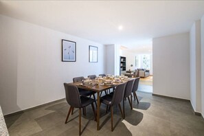 A dining area with a table set for four, chairs, and framed pictures on the wall.