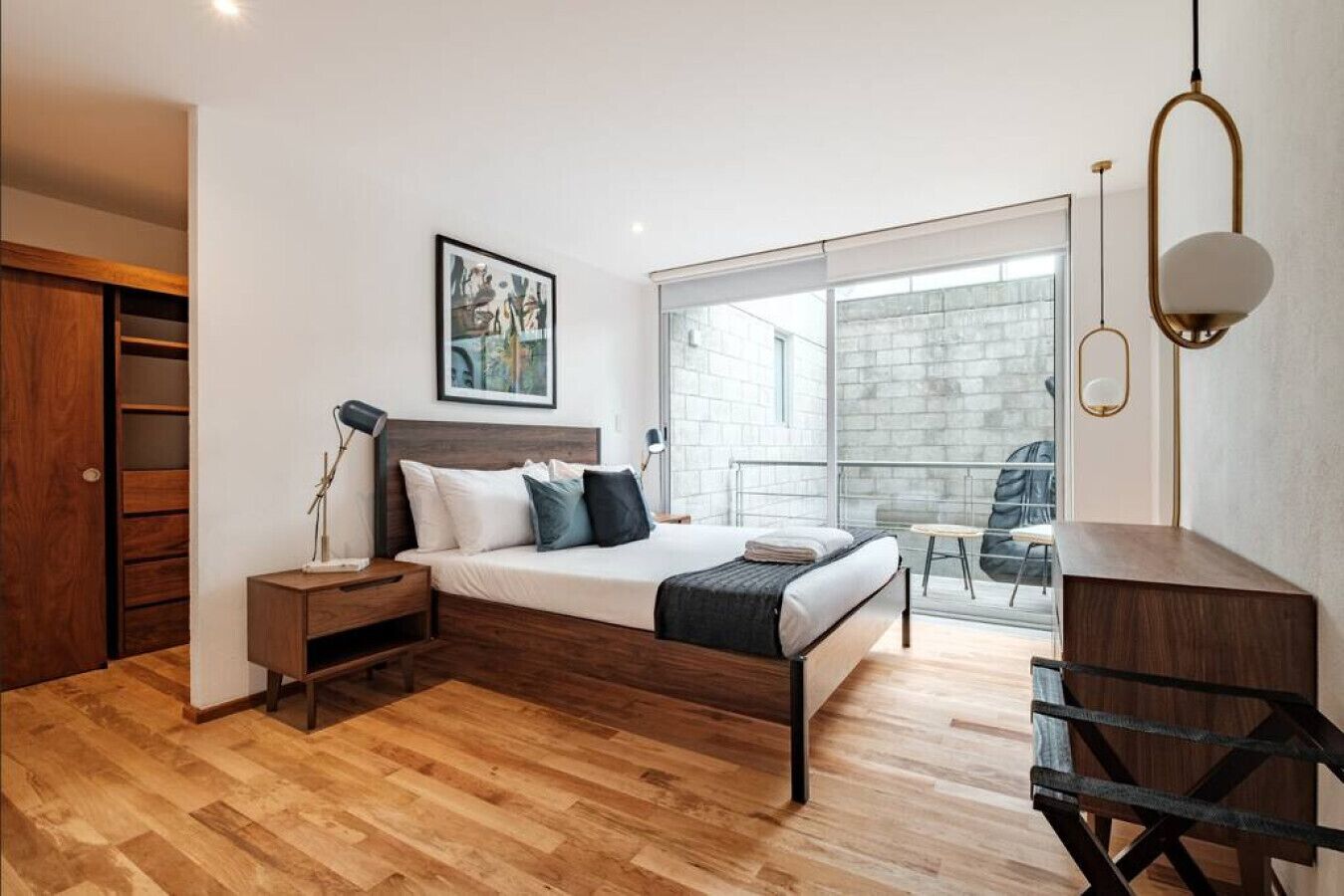 Une chambre à coucher moderne avec un lit, une table de chevet et un bureau.