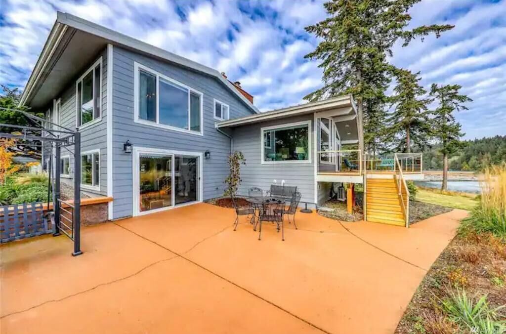 A two-story house with a covered patio and a staircase leading to a deck.