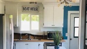 A kitchen with white cabinets, a microwave, a sink, and a ceiling fan. - Beautiful Oceanview Retreat 2 Bedroom Home (Port Hadlock-Irondale)