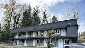 A two-story motel with numbered rooms, a balcony, and a parking area.